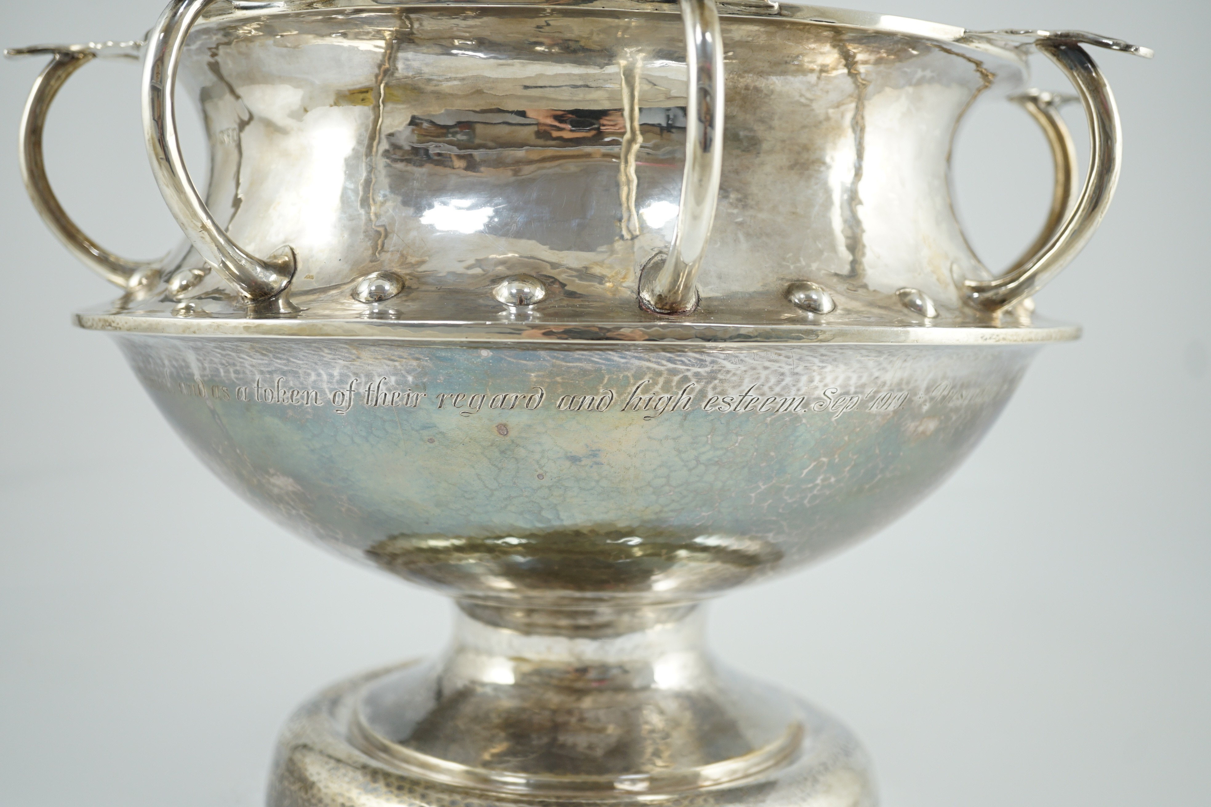 A George V Arts & Crafts planished silver octuple handled pedestal punch bowl, by Albert Edward Jones